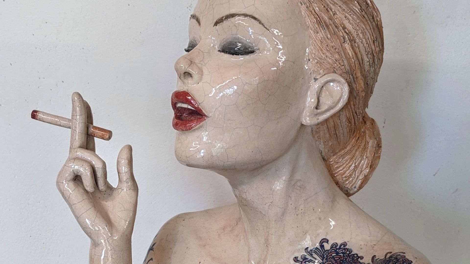 Sculpture céramique cuisson raku d'une femme qui fume une cigarette